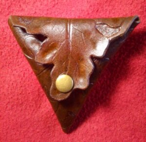 Trójkątna bilonówka ze skóry. Zamknięcia w formie liści. Dwustronna.