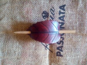 Bordowa spinka do włosów zrobiona ze skóry.