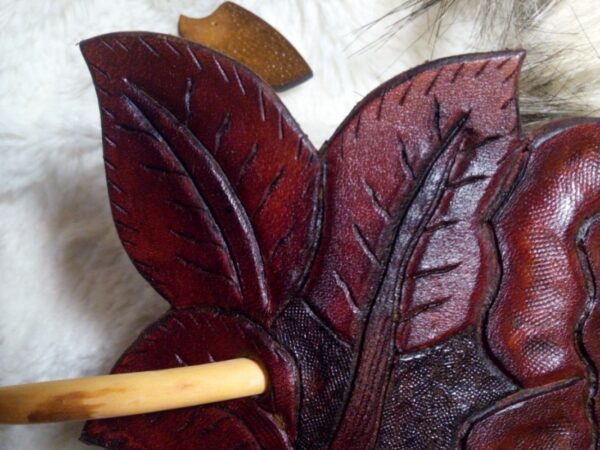 Zbliżenie liści spinki do włosów zrobionej ze skóry.