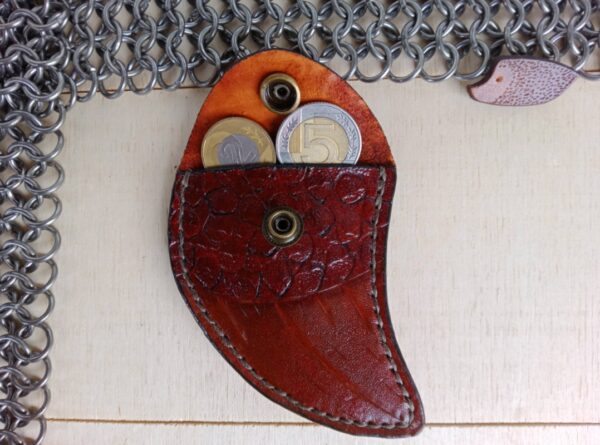 Przód skórzanej bilonówki z dwoma monetami wystającymi ze środka..