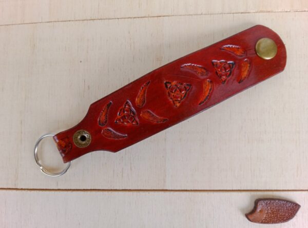 Skórzany brelok do kluczy z wyrzeźbionymi skrzydłami.