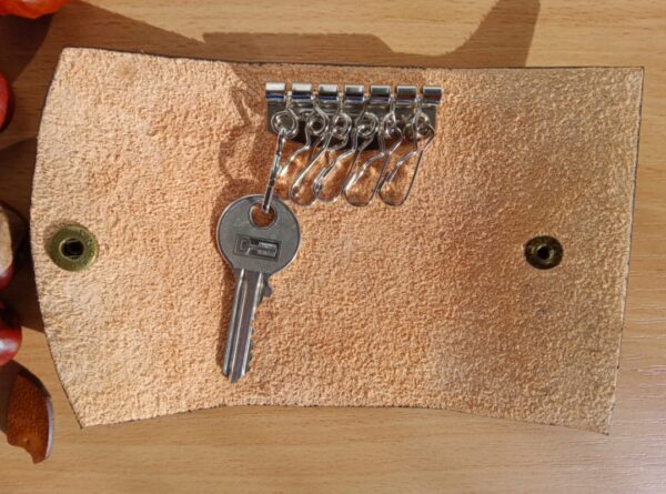 Rozłożone etui na klucze ze skóry.