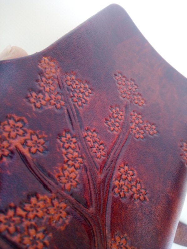 Zbliżenie na kwiaty wiśni skórzanego etui na klucze.