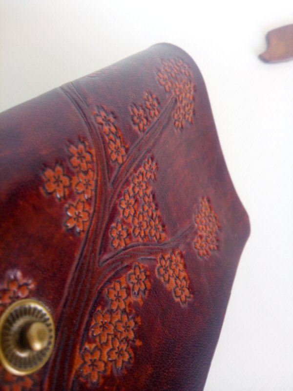 Zbliżenie na kwiaty wiśni skórzanego etui na klucze.