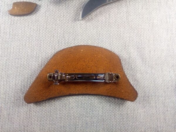 Tył skórzanej spinki do włosów z krokodylem.