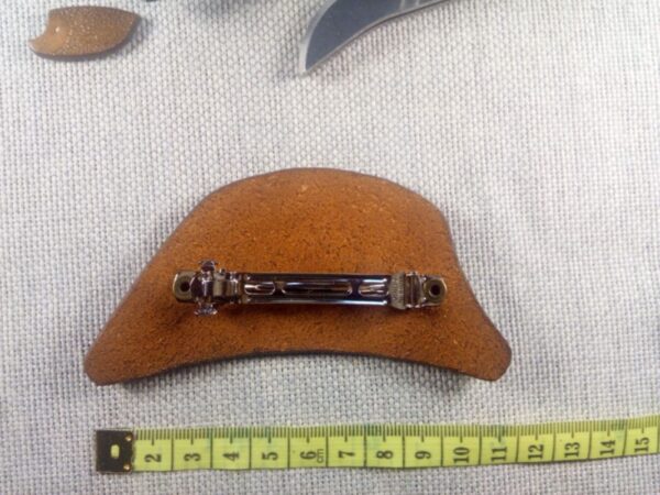 Tył spinki do włosów ze skóry naturalnej z miarą krawiecką.