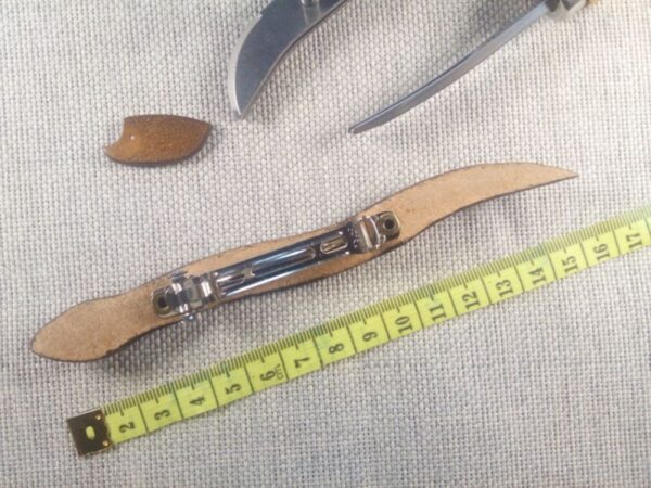 Tył skórzanej spinki do włosów z miarą.