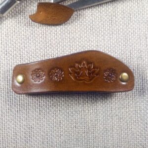 Skórzana spinka do włosów z joginem. Widok z przodu.