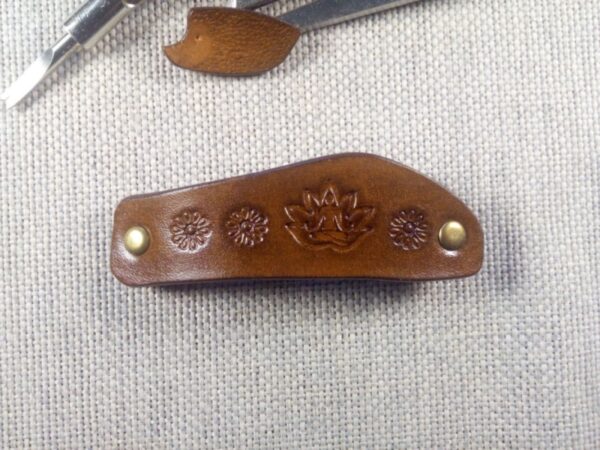 Skórzana spinka do włosów z joginem. Widok z przodu.