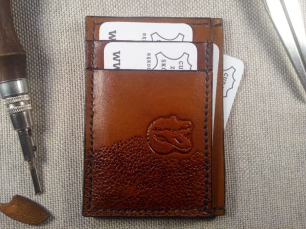 Widok od przodu na skórzane etui na karty płatnicze z krokodylem z włożonymi kartami.