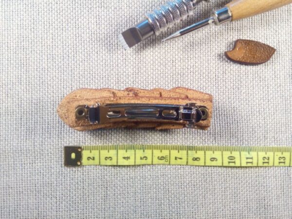 Skórzana spinka do włosów z miarą krawiecką.