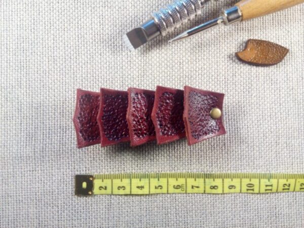 Ujęcie od przodu na skórzaną spinkę do włosów w kolorze bordo.