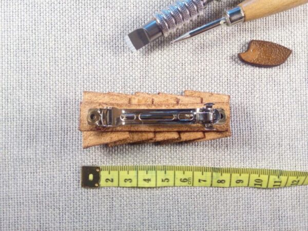 Widok na klamrę spinki do włosów z miara krawiecką.