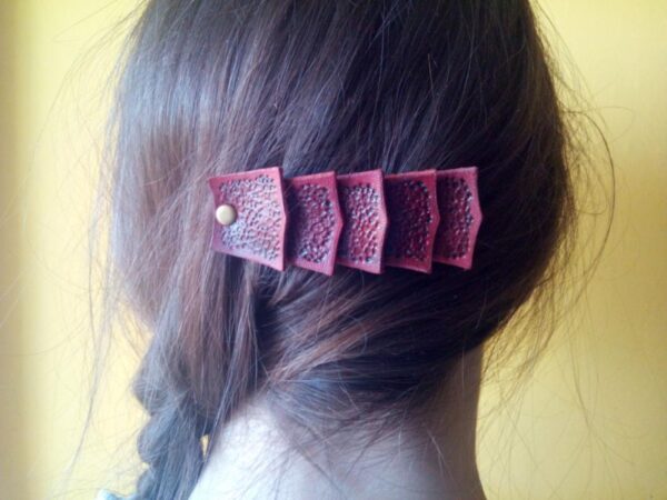 Skórzana spinka do włosów przypięta do włosów. Widok na głowę od tyłu.