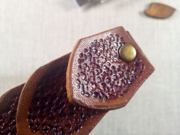 Zbliżenie na brązową łuskę skórzanej spinki do włosów.