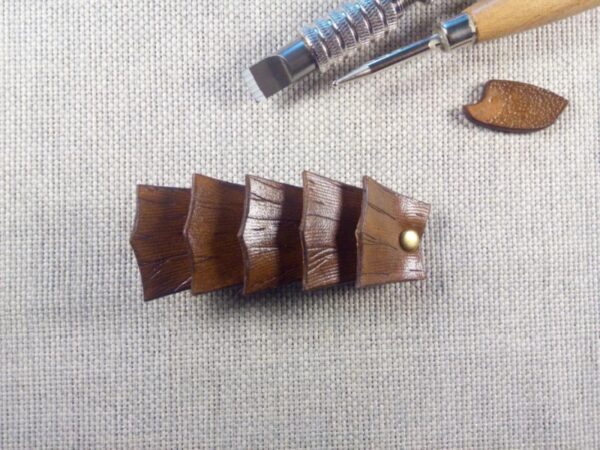 Widok do przodu - skórzana spinka do włosów wykonana z pięciu łusek nadrzewnego smoka.