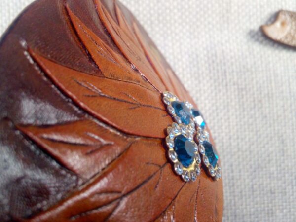 Zbliżenie na skórzaną spinkę do włosów ozdobioną kryształkami.