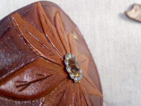 Zbliżenie na kwiat z kryształkiem skórzanej spinki do włosów.