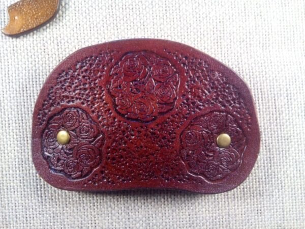Widok od przodu na skórzaną spinkę do włosów z różami.