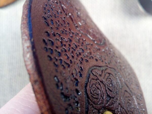 Zbliżenie na róże skórzanej spinki do włosów.