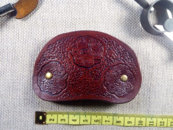 Widok od przodu na skórzaną spinkę do włosów z różami z mirą krawiecką.