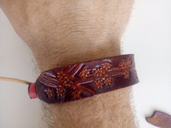 Skórzana bransoletka "Kwiaty wiśni" na ręce - przód.