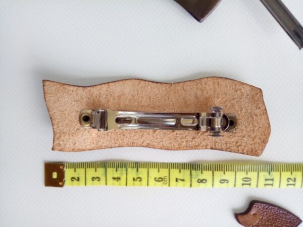 Tył skórzanej spinki do włosów z kwiatami wiśni z miarą krawiecką.