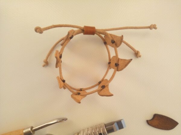 Skórzana bransoletka z listkami - widok z góry ściągnięta rzemieniami.